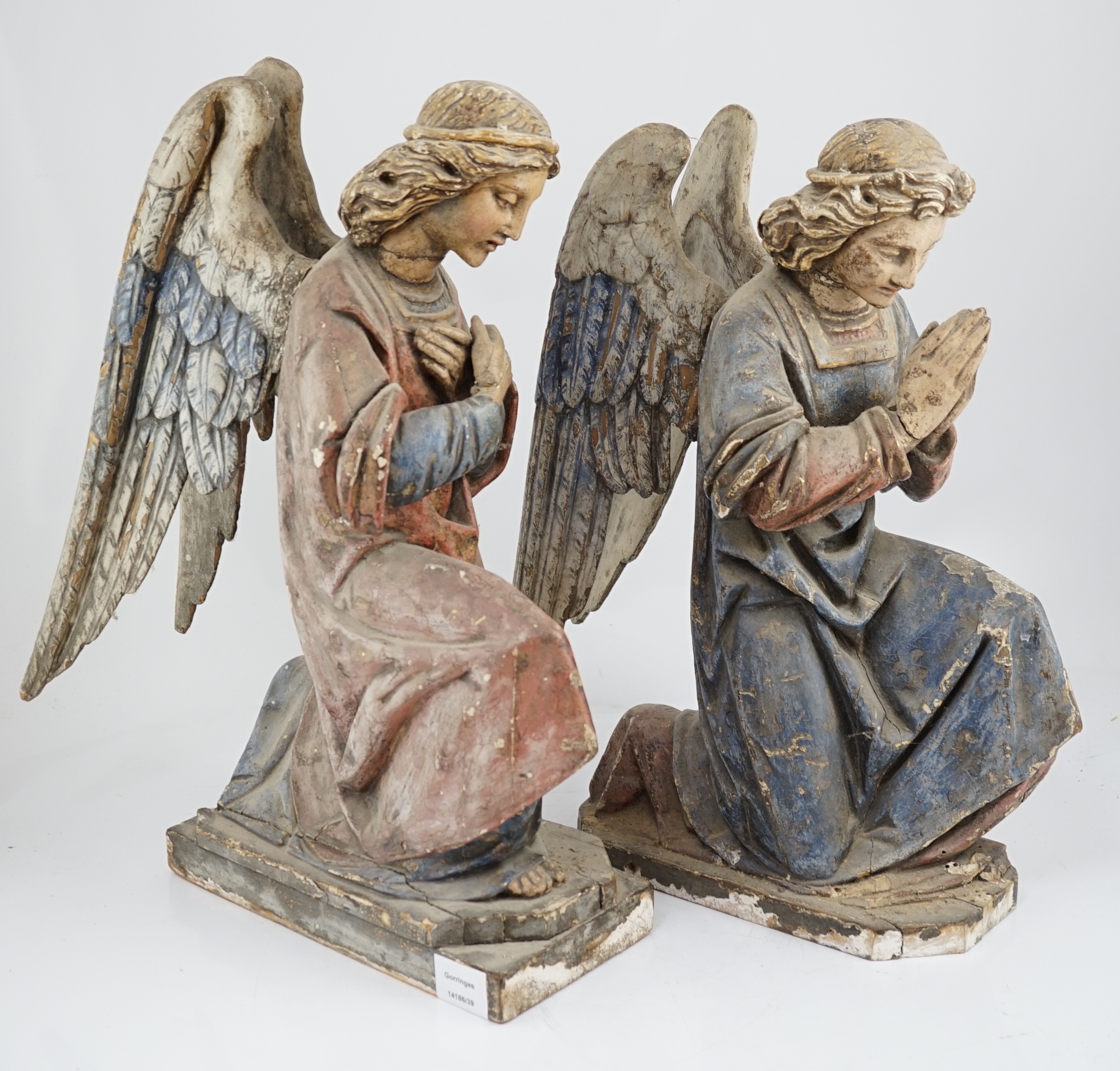 A pair of late 19th century polychrome carved painted pine praying archangels